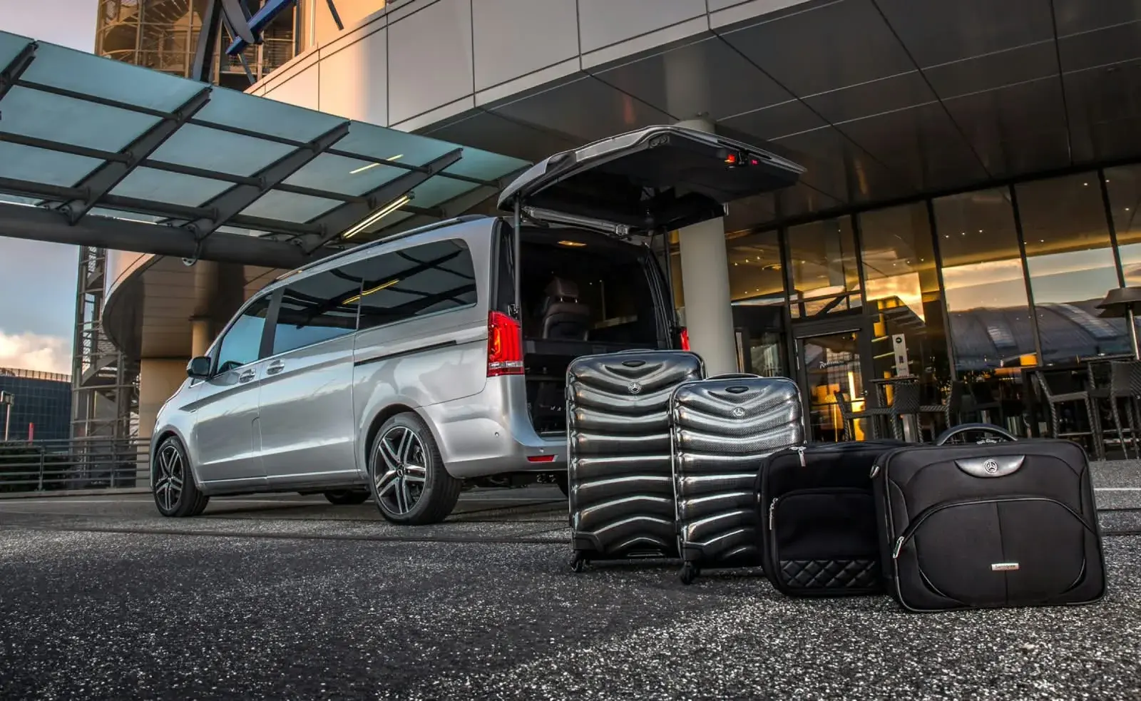 Трансфер отеля G Empire — минивэн Mercedes-Benz V-Class с багажом у входа